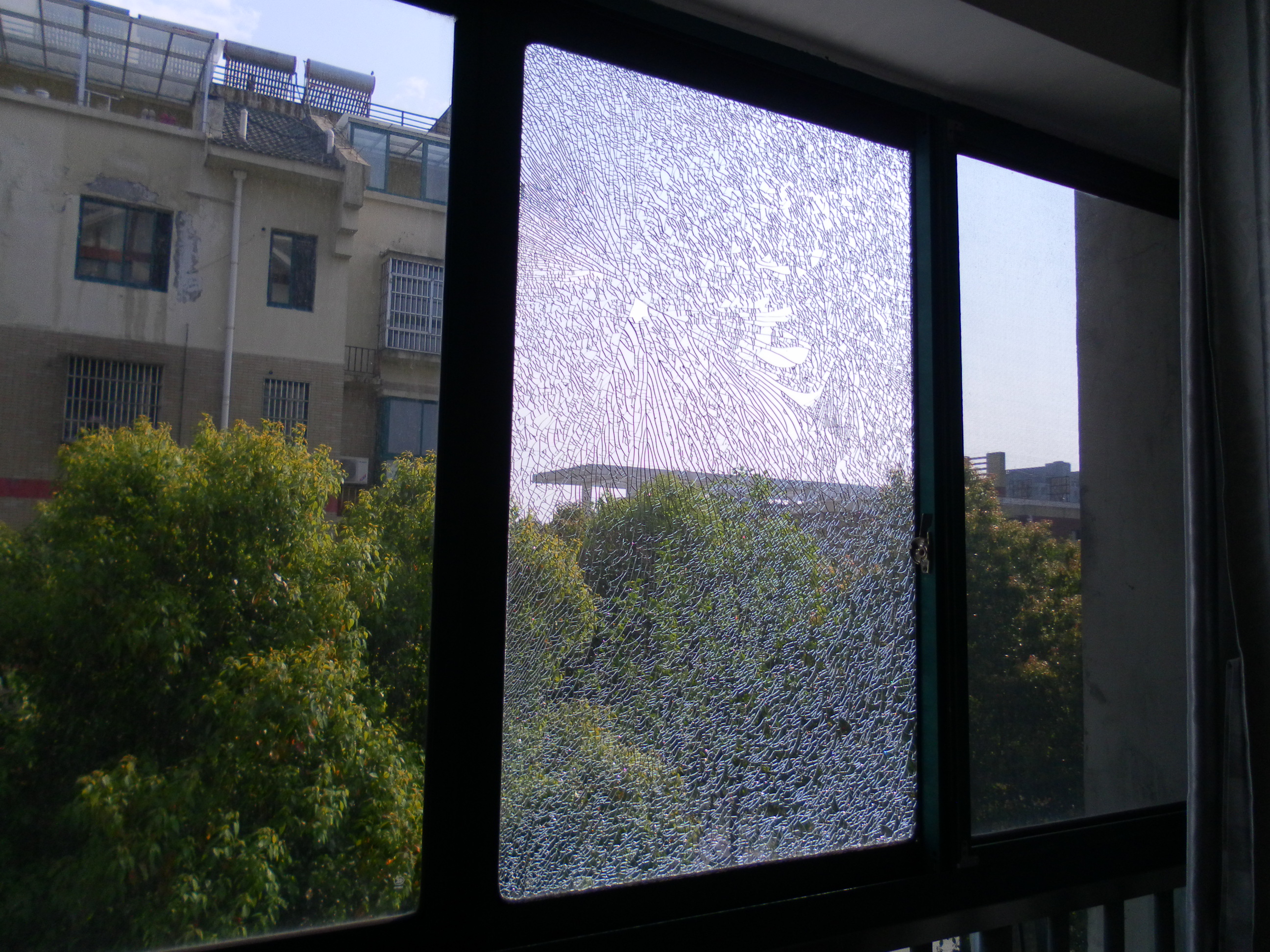 好好的窗台玻璃被硬物击穿,玻璃碎片洒落一地!